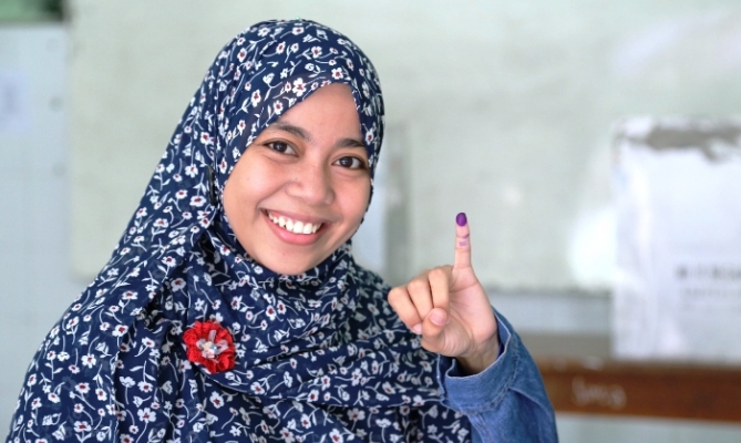 Pemilih yang telah menggunakan hak pilihnya memperlihatkan tanda tinta pada jari tangan sebagai tanda telah menggunaka hak pilihnya.