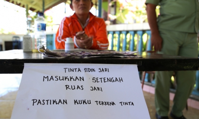 Pemberitahuan dari KPPS terkait tata cara untuk mencelupkan jari ke tinta, dalam Pemilu Presiden dan Wakil Presiden Tahun 2014, di Sulawesi Utara, (9/7).