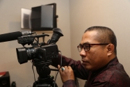 Staf  Humas Bawaslu Abdul Hamid Idrus mempraktekan pengambilan gambar lewat video camera ketika melakukan Produksi Program dan Berita  Studio Audio Visual di Lt. 4 Gedung Bawaslu RI, Kamis (22/1). 